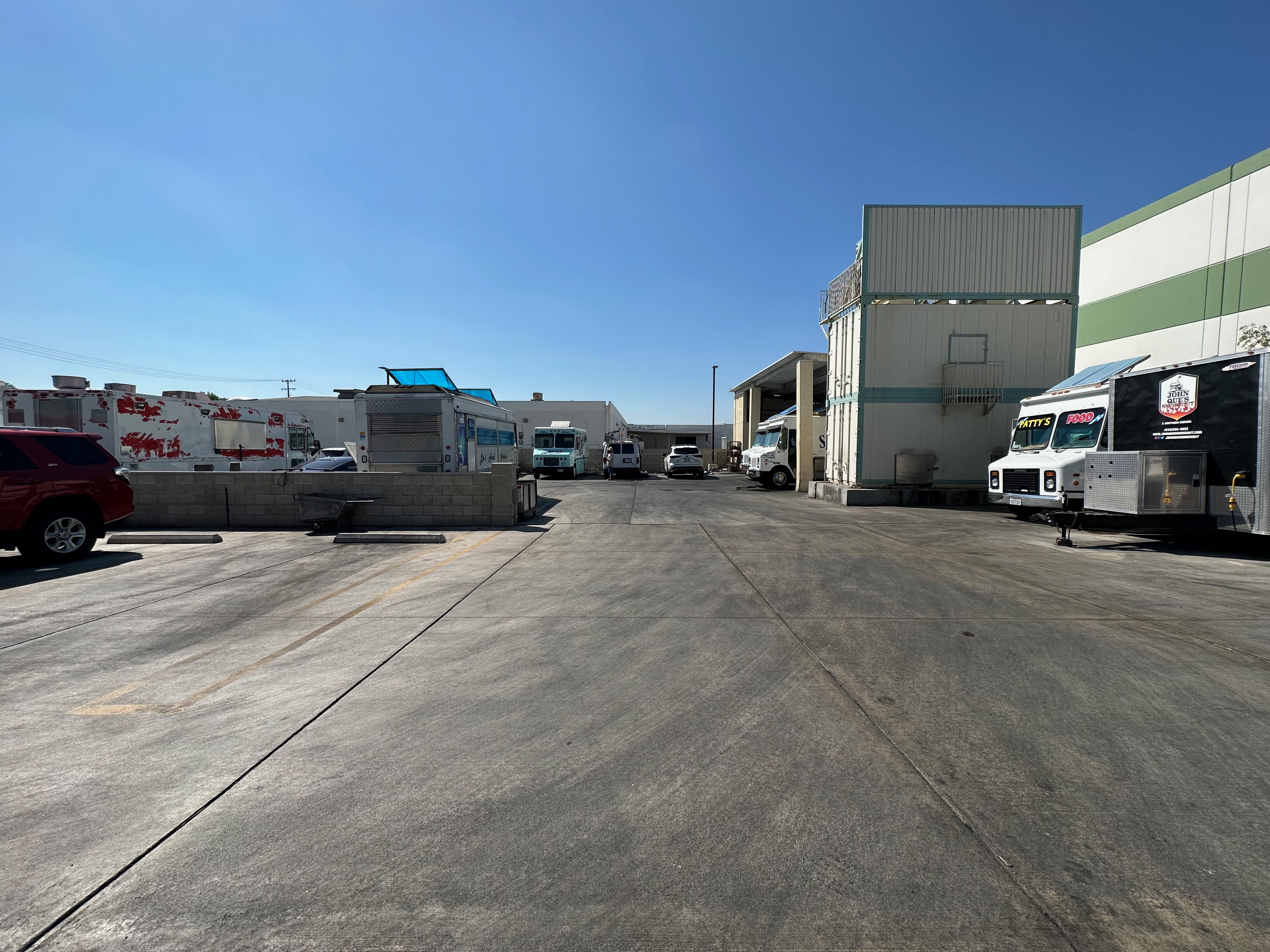 Food trucks parked in the gated lot at Fast Dash Commissary in Anaheim